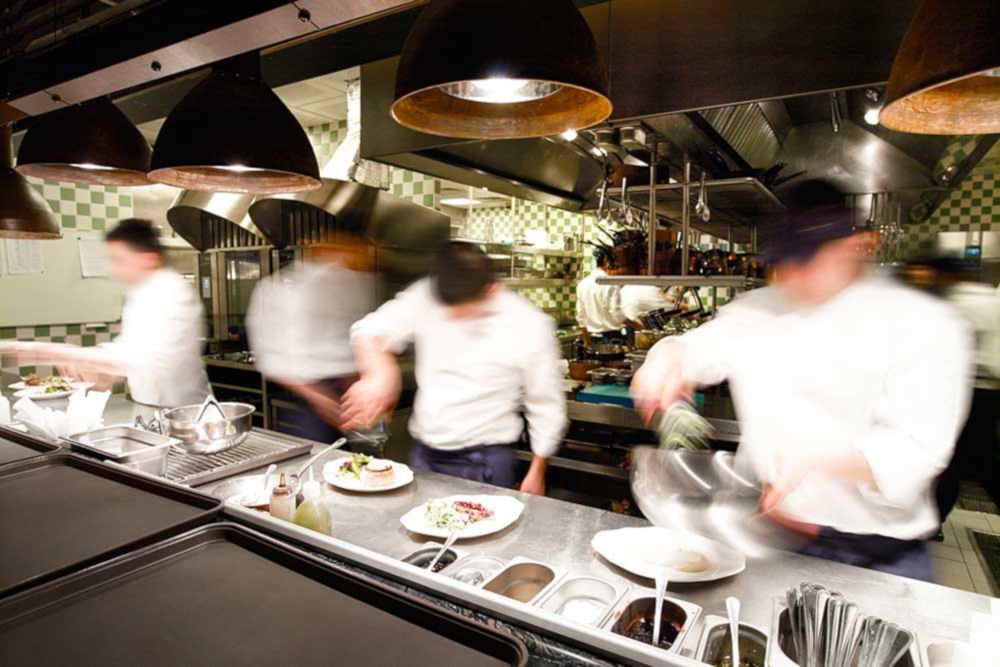 Busy kitchen with chefs preparing catered food