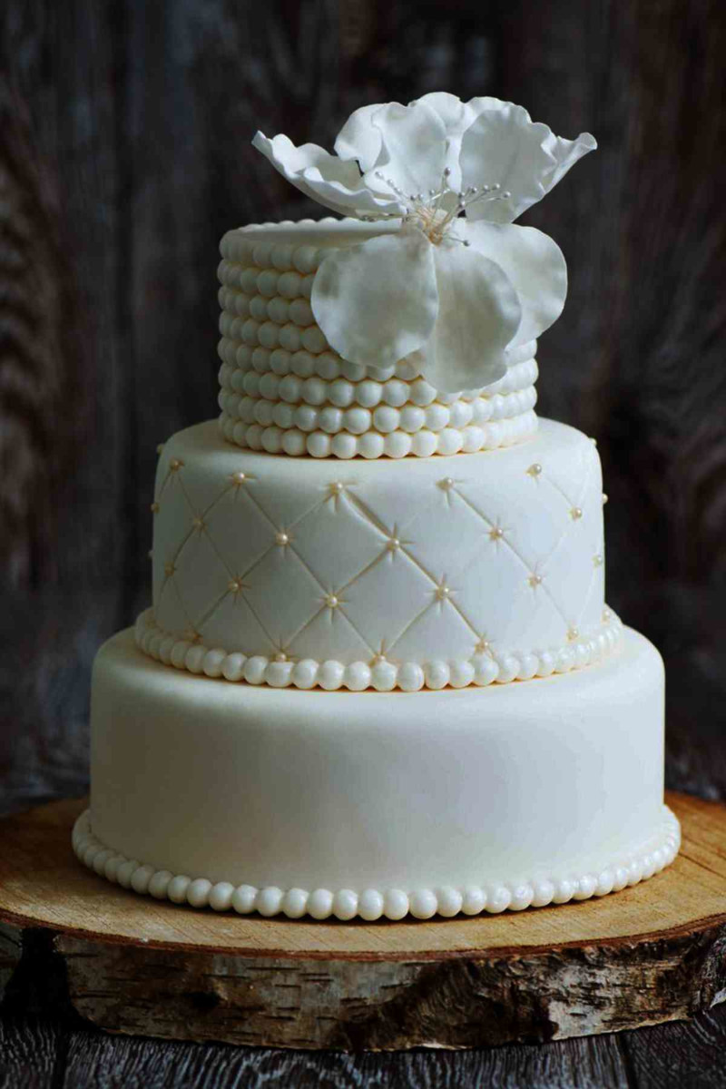 Sophisticated 4 tier white fondant wedding cake decorated with an alternating quilt pattern