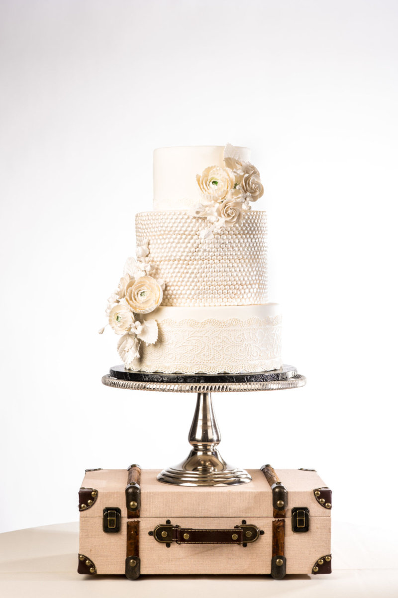 Dessert cake with white cream, lace and white roses decorations